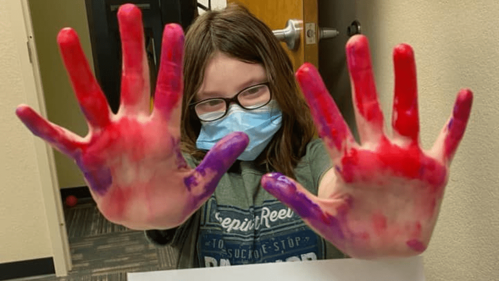 Young girl doing finger painting at Jarvis Pediatric Therapy